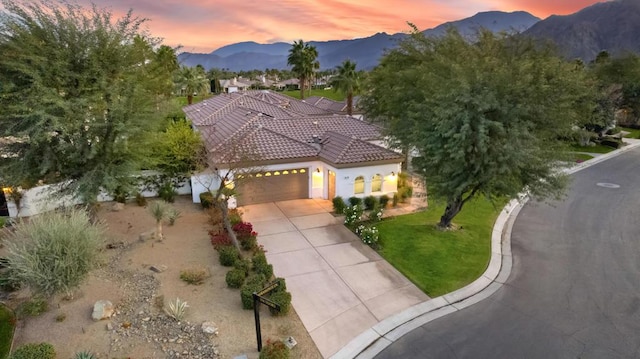 mediterranean / spanish-style house with a mountain view, a yard, and a garage