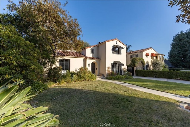 mediterranean / spanish house featuring a front yard