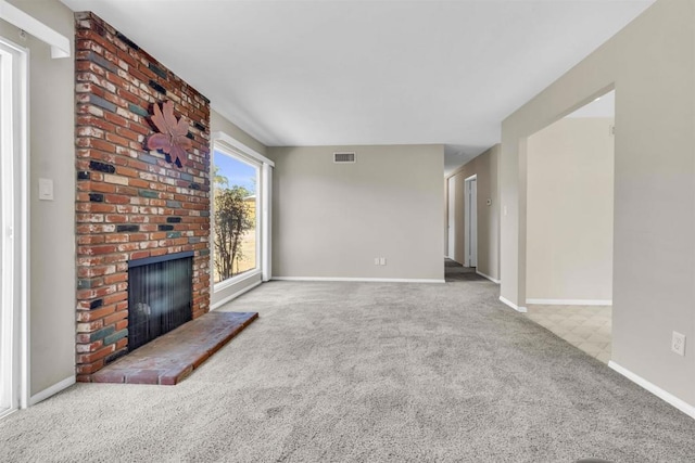 unfurnished living room with light carpet and a brick fireplace