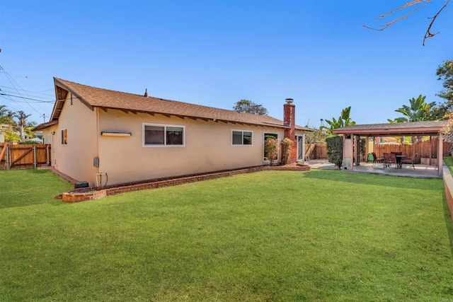 rear view of house featuring a lawn and a patio