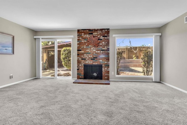 unfurnished living room featuring a fireplace, carpet floors, and plenty of natural light