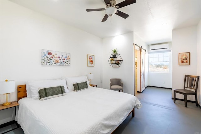 bedroom featuring ensuite bath, concrete floors, an AC wall unit, ceiling fan, and a barn door