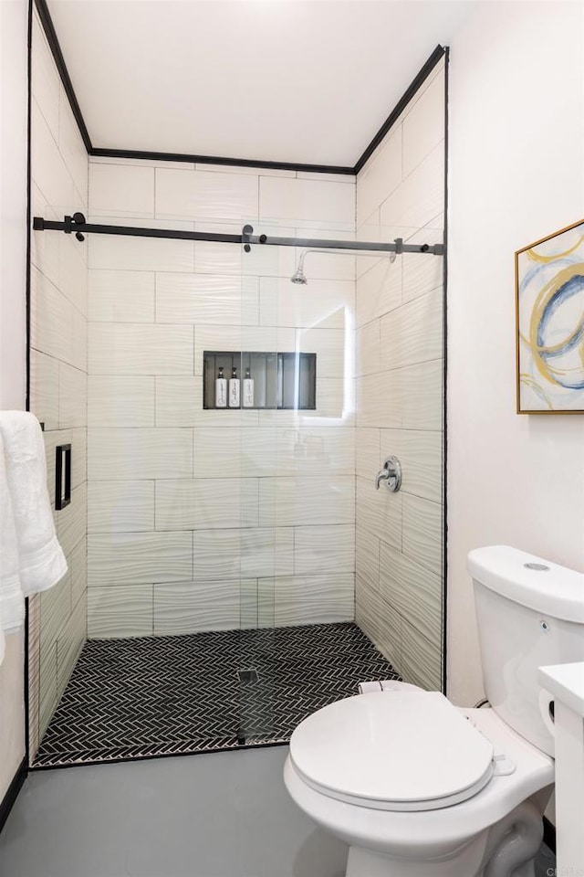 bathroom with vanity, a shower with door, concrete floors, and toilet