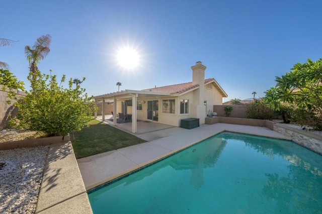 back of property featuring a fenced in pool and a patio area