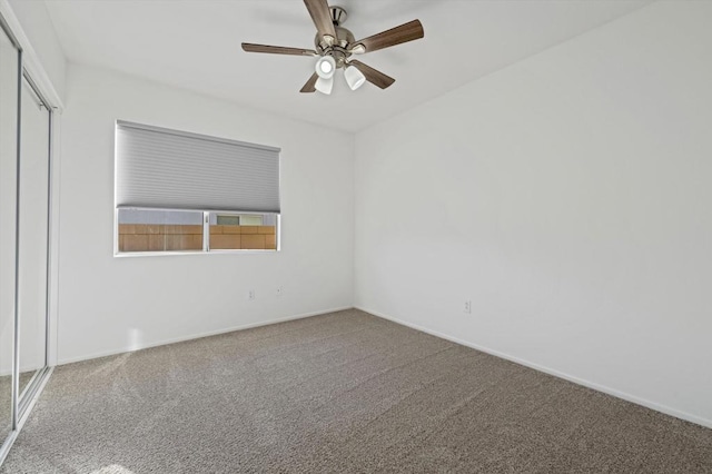 carpeted spare room featuring ceiling fan