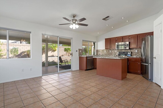 kitchen featuring ceiling fan, light tile patterned flooring, lofted ceiling, and appliances with stainless steel finishes