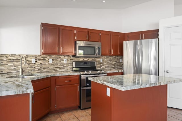 kitchen featuring stainless steel appliances, vaulted ceiling, a kitchen island, and sink