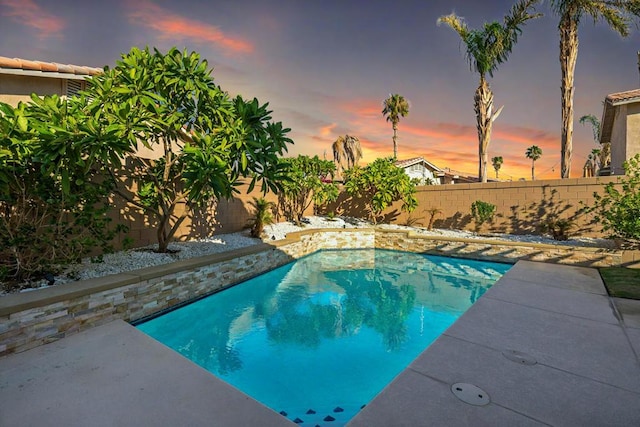 view of pool at dusk