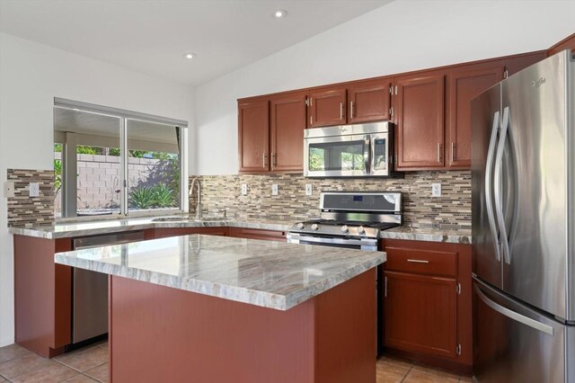 kitchen featuring a center island, sink, stainless steel appliances, backsplash, and vaulted ceiling