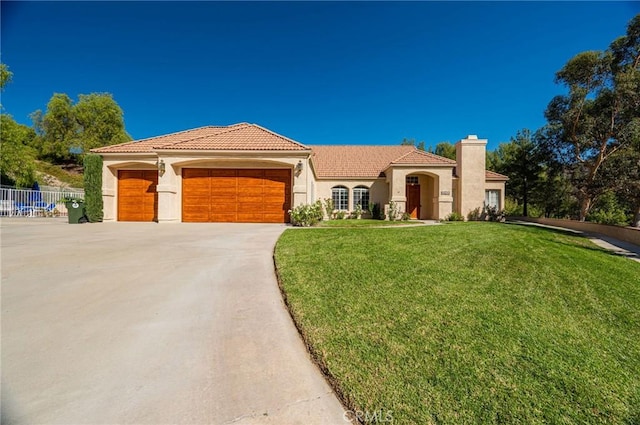 mediterranean / spanish home featuring a front lawn and a garage