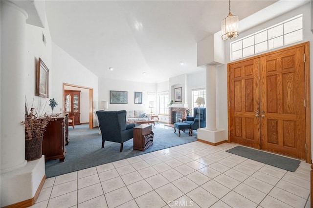 tiled entrance foyer featuring high vaulted ceiling and an inviting chandelier