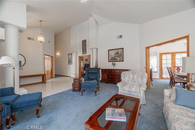 living room featuring high vaulted ceiling, light colored carpet, and an inviting chandelier