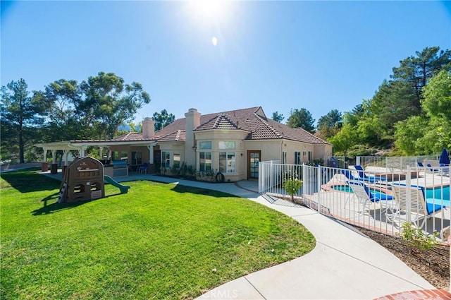 back of property featuring a yard, a fenced in pool, and a patio