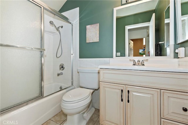 full bathroom with toilet, tile patterned flooring, vanity, and combined bath / shower with glass door