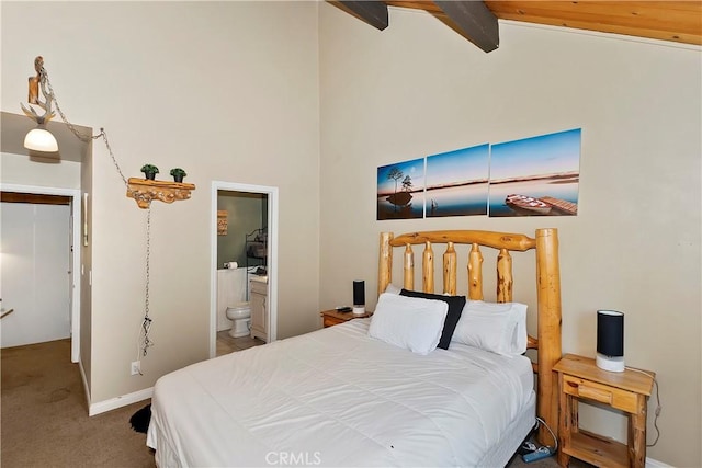 carpeted bedroom featuring beam ceiling, ensuite bath, and high vaulted ceiling