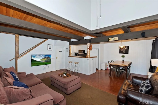 living room featuring beamed ceiling, wood-type flooring, and wood ceiling