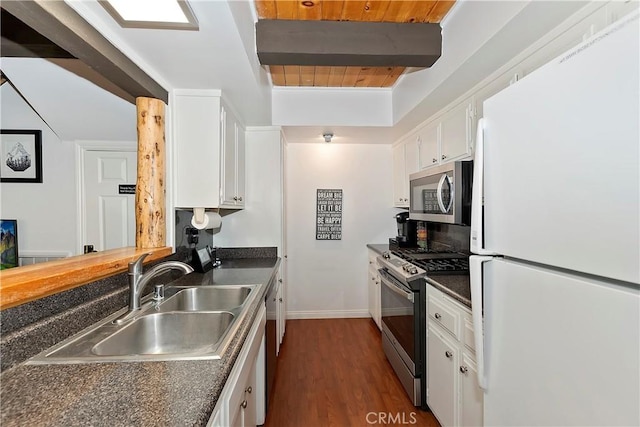 kitchen featuring beam ceiling, white cabinetry, sink, and stainless steel appliances