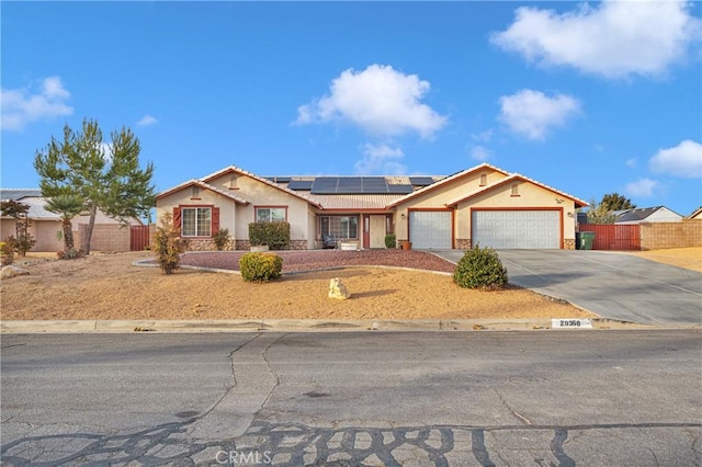 single story home featuring solar panels and a garage