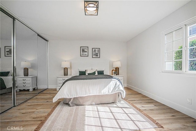 bedroom with light wood-type flooring and a closet