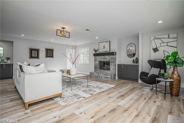 living room featuring a fireplace and light wood-type flooring