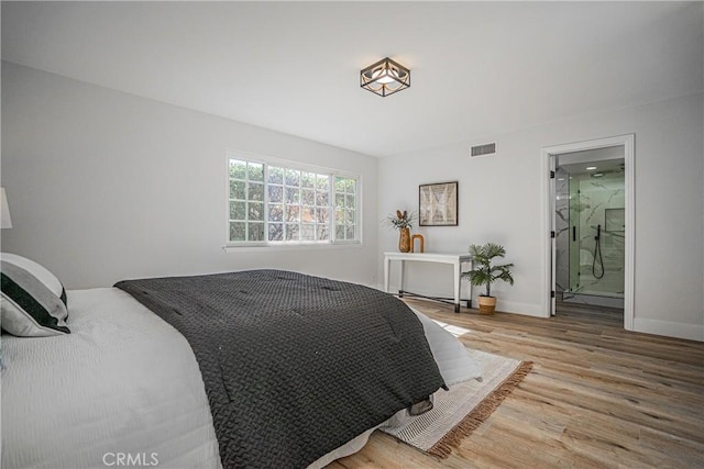 bedroom featuring hardwood / wood-style flooring and ensuite bathroom