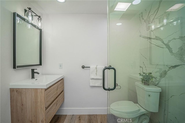 bathroom with wood-type flooring, vanity, toilet, and walk in shower