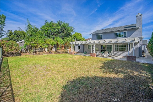 rear view of house with a lawn, a pergola, and a patio