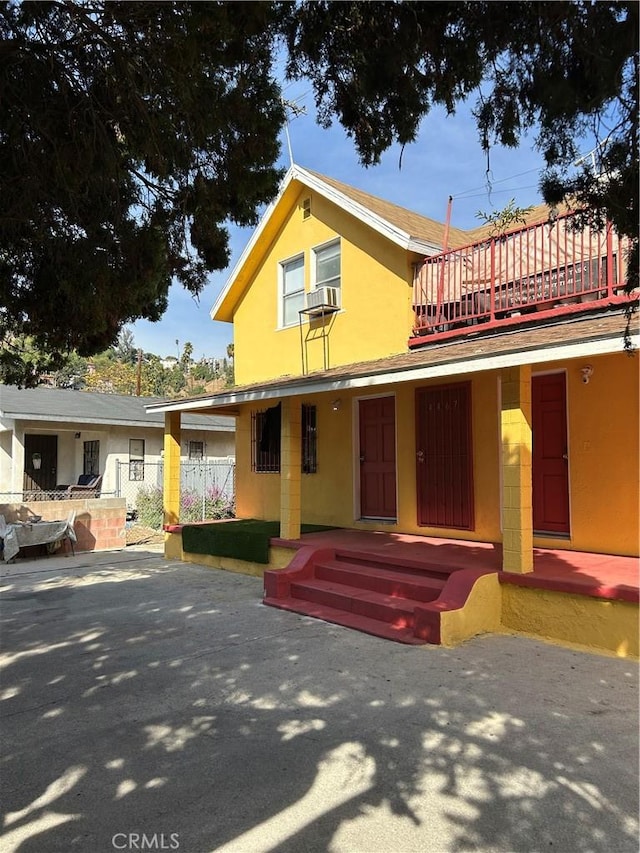 view of front of house featuring a balcony and cooling unit