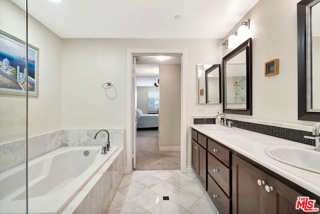 bathroom featuring vanity and a relaxing tiled tub