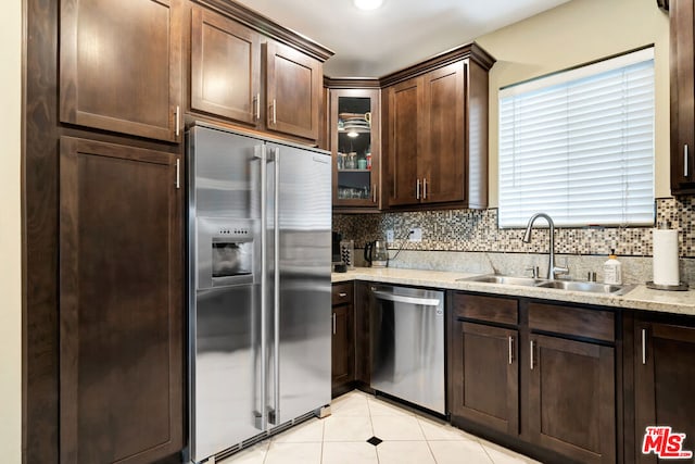 kitchen with tasteful backsplash, dark brown cabinetry, sink, and stainless steel appliances