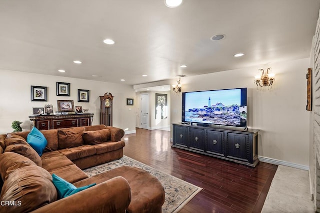 living room featuring dark wood-type flooring and a notable chandelier