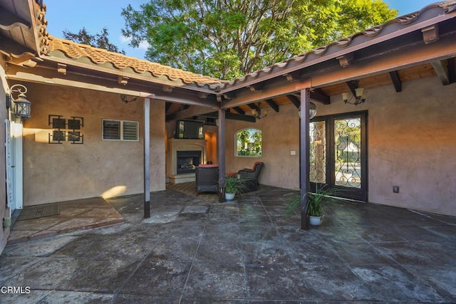 view of patio with exterior fireplace and french doors