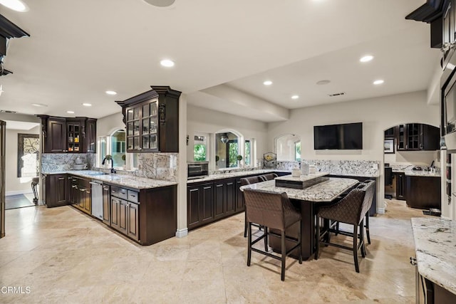 kitchen featuring dark brown cabinets, sink, kitchen peninsula, and stainless steel appliances