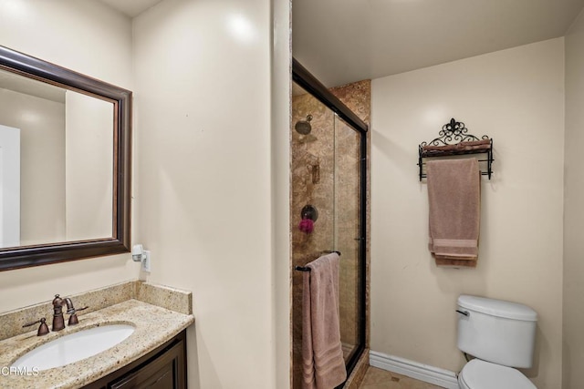 bathroom with vanity, a shower with shower door, and toilet