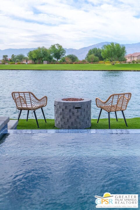 view of swimming pool with a yard and a water and mountain view