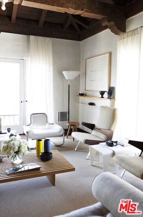 carpeted living room featuring beamed ceiling