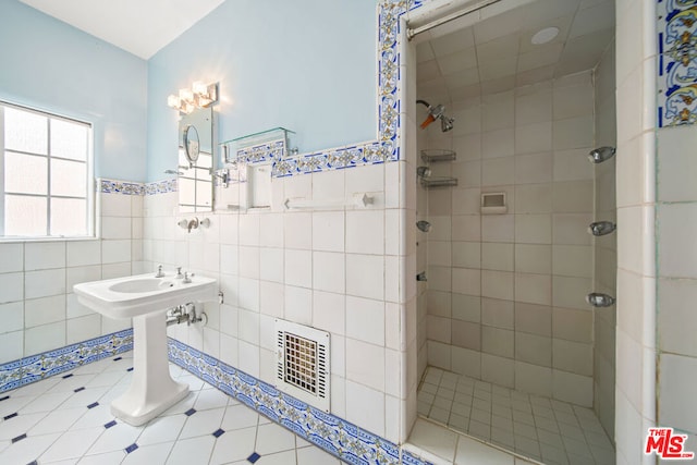 bathroom with a tile shower and tile walls