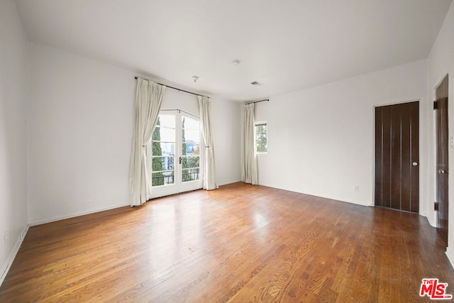 spare room featuring wood-type flooring and french doors