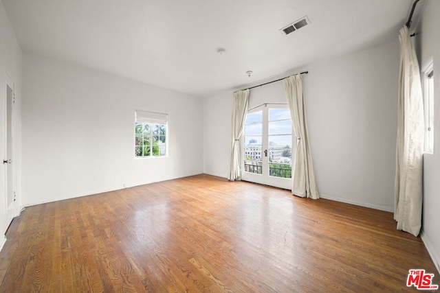 unfurnished room with hardwood / wood-style floors and a healthy amount of sunlight