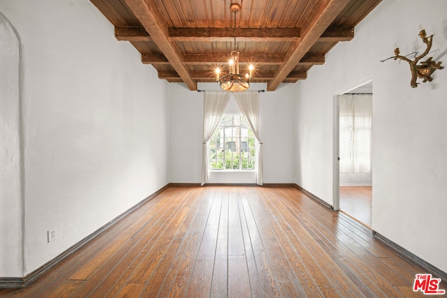 spare room featuring hardwood / wood-style floors, a notable chandelier, beam ceiling, and wood ceiling