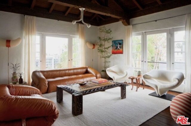 living room with beamed ceiling, hardwood / wood-style flooring, and a wealth of natural light