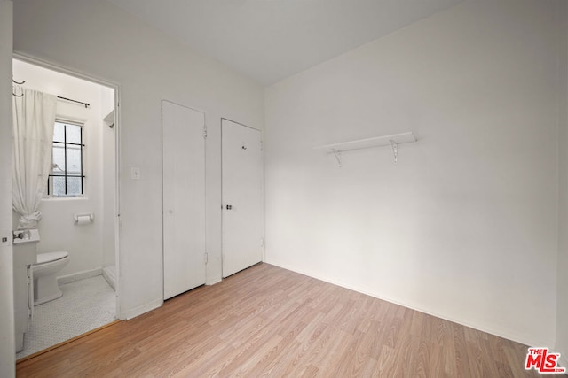 interior space featuring ensuite bathroom and light hardwood / wood-style flooring