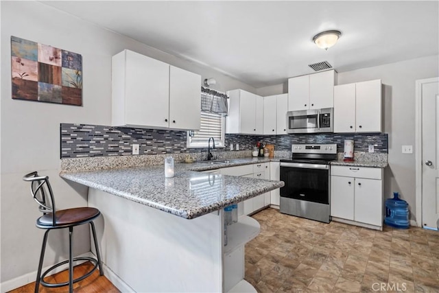 kitchen featuring a breakfast bar area, kitchen peninsula, and stainless steel appliances