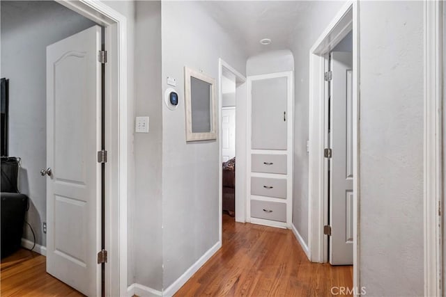 corridor with light hardwood / wood-style floors