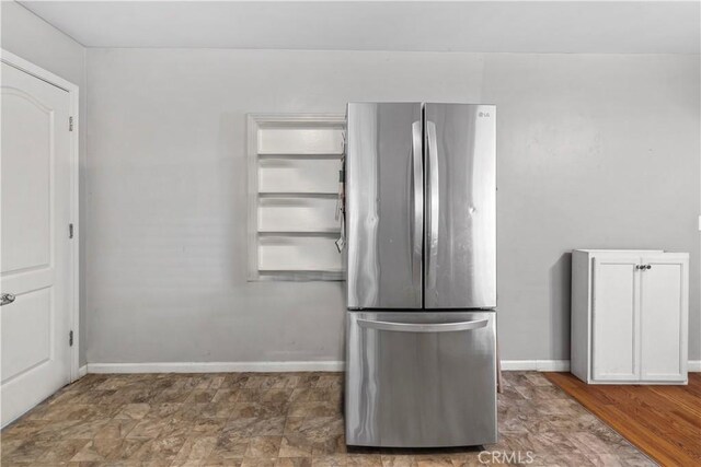 kitchen featuring dark hardwood / wood-style floors, white cabinetry, and stainless steel refrigerator