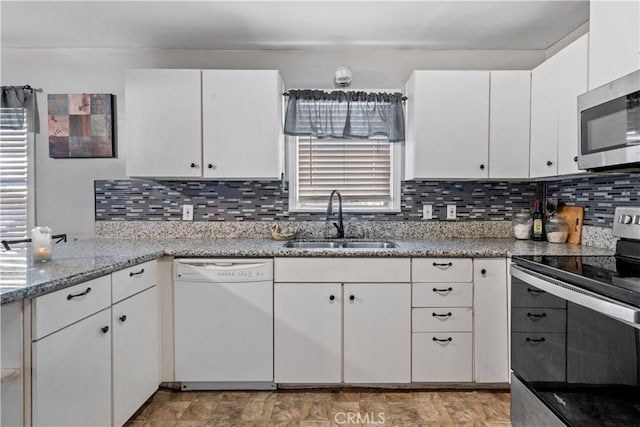 kitchen featuring backsplash, white cabinetry, sink, and stainless steel appliances