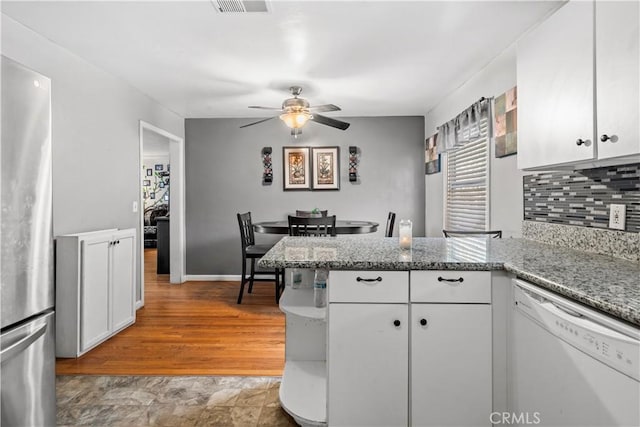 kitchen with white cabinetry, light stone countertops, ceiling fan, stainless steel fridge, and white dishwasher