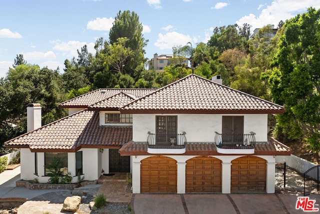 mediterranean / spanish house with a balcony and a garage