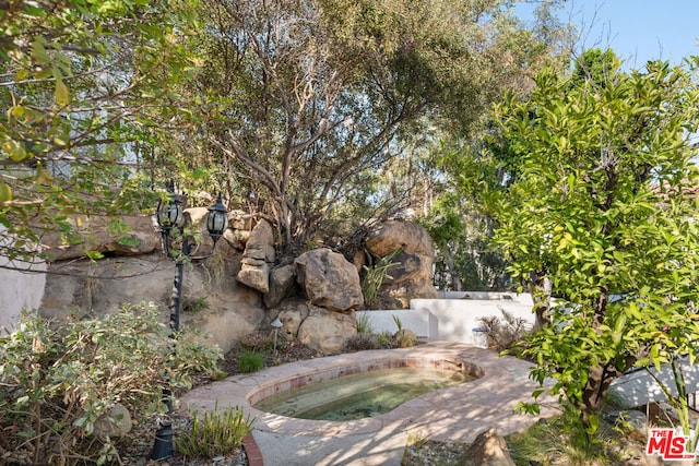 exterior space featuring an in ground hot tub