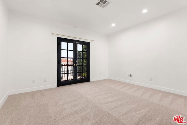 unfurnished room featuring light colored carpet and french doors